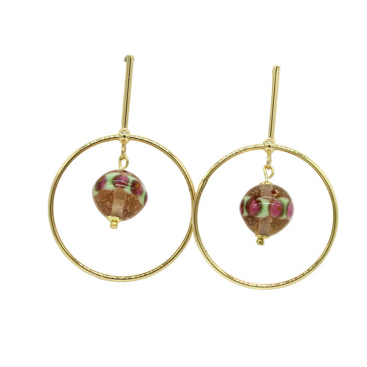 Paire de boucles d'oreilles pendantes formées d'un grand cercle en acier doré suspendu à une tige avec fermoir en acier, abritant en son centre une perle ronde en verre de Murano rose poudré, vert et bordeaux.