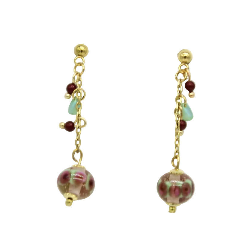 Paire de boucles d'oreilles pendantes sur chaînes en acier doré avec fermoir puces en acier, ornées de pampilles de perles de Murano roses, vertes et bordeaux.