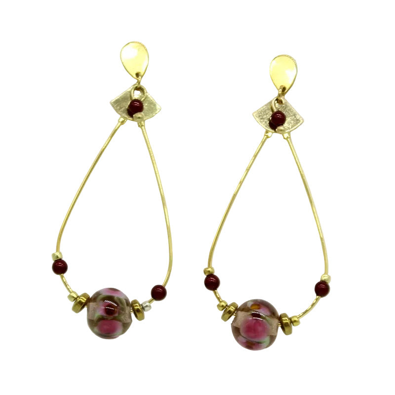 Paire de grandes boucles d'oreilles pendantes en forme de créoles ovales en acier doré avec fermoir en acier, surmontées d'un motif éventail et ornées d'une perle centrale en verre de Murano rose, vert et bordeaux et de petites perles.