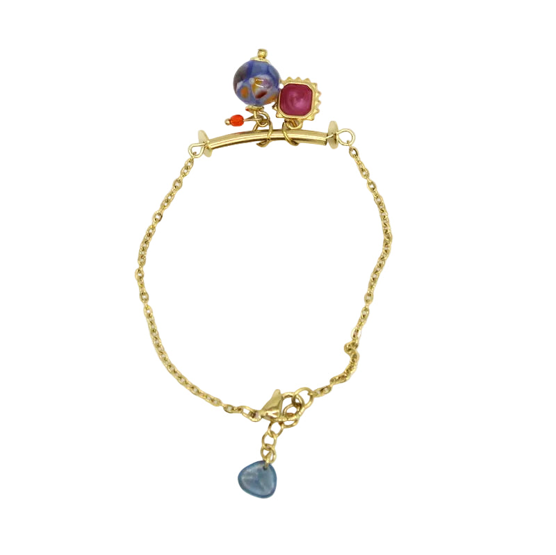 Bracelet fin en chaîne d'acier doré avec une fine barre courbe supportant des pampilles et une perle en verre de Murano bleue.