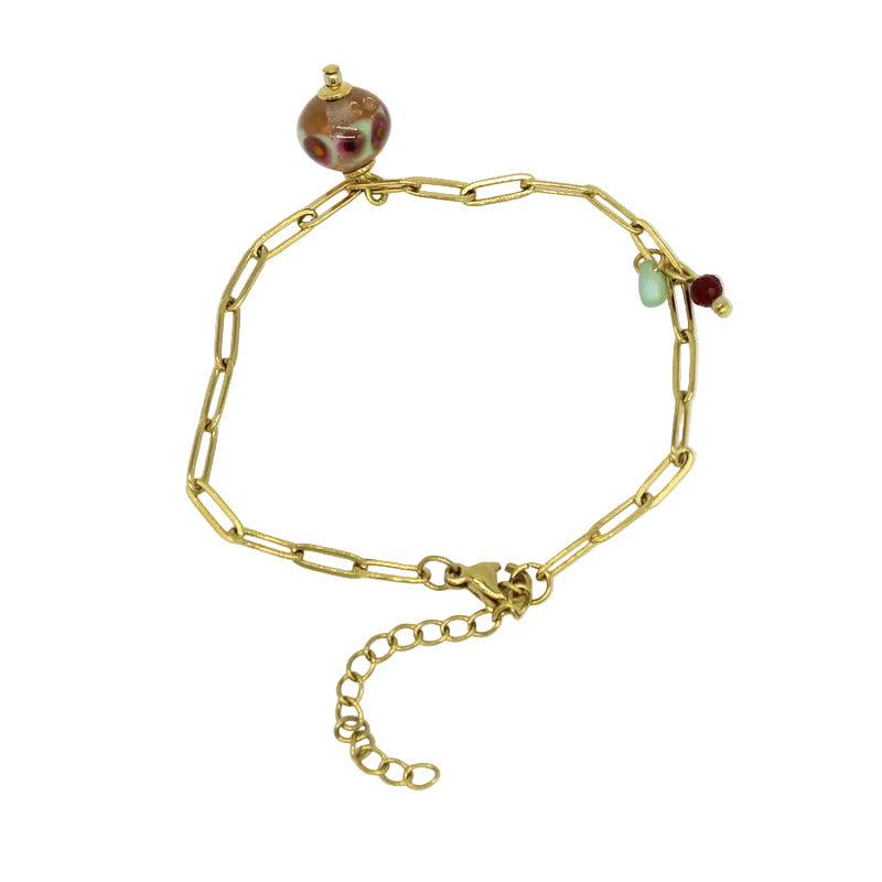 Bracelet en chaîne à mailles rectangulaires en acier doré, orné d'un pendentif en perle de verre de Murano rose poudré, vert et bordeaux.