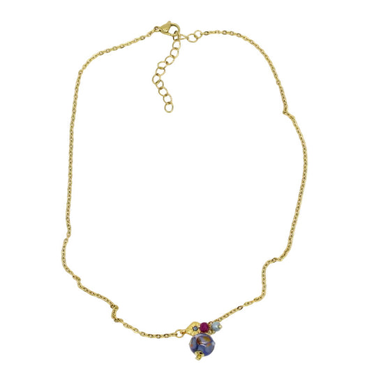 Collier ras de cou en chaîne d'acier doré agrémenté d'un motif losange, de petites perles et d'un pendentif en perle de verre de Murano bleue.