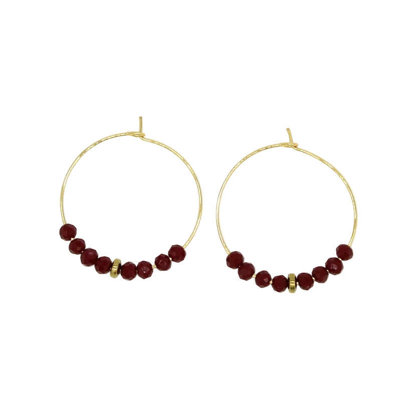 Paire de créoles rondes en acier doré avec fermoir en acier, ornées à leur base d'une ligne de perles facettées en verre de Murano bordeaux et d'un séparateur doré.