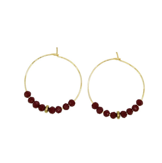 Paire de créoles rondes en acier doré avec fermoir en acier, ornées à leur base d'une ligne de perles facettées en verre de Murano bordeaux et d'un séparateur doré.
